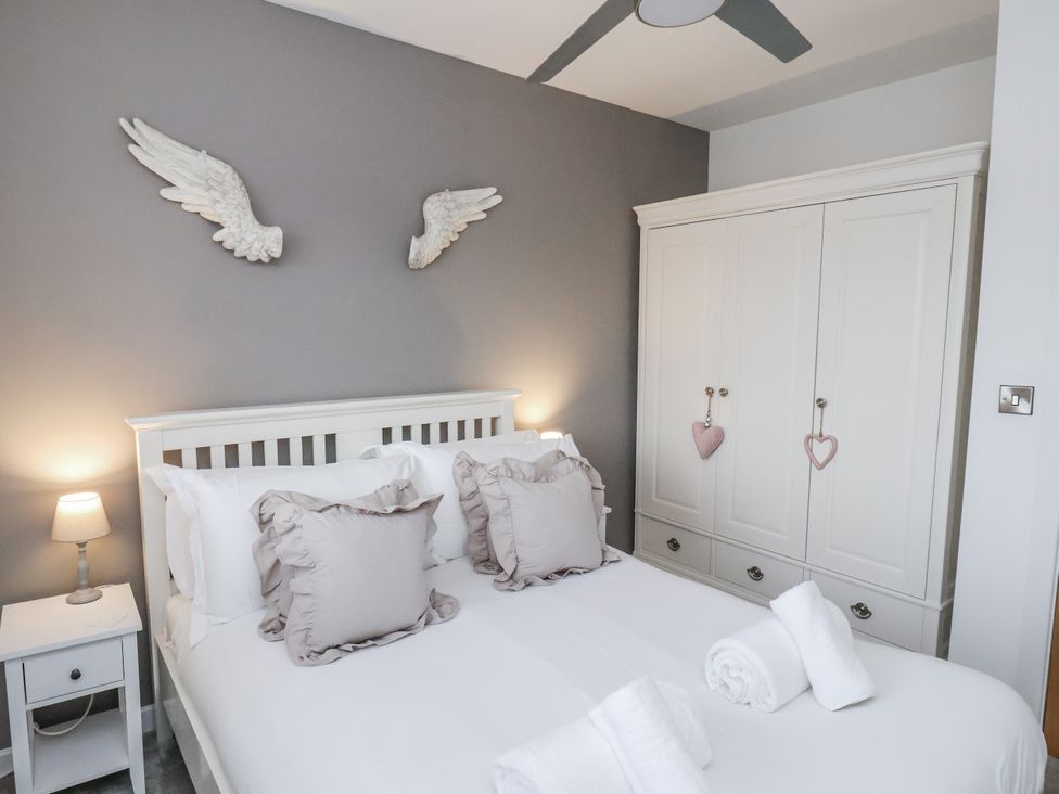 A bedroom with a bed and wardrobe at Pearl Stone House in Whitby