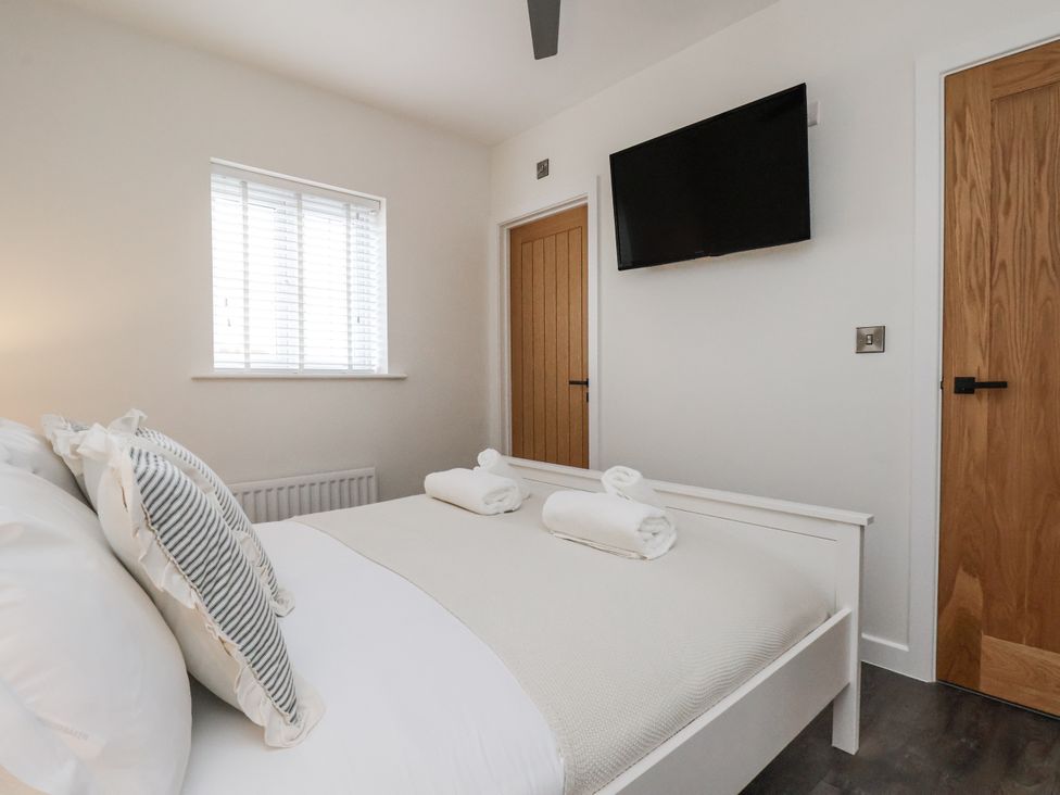 A bedroom with a bed and television at Pearl Stone House in Whitby