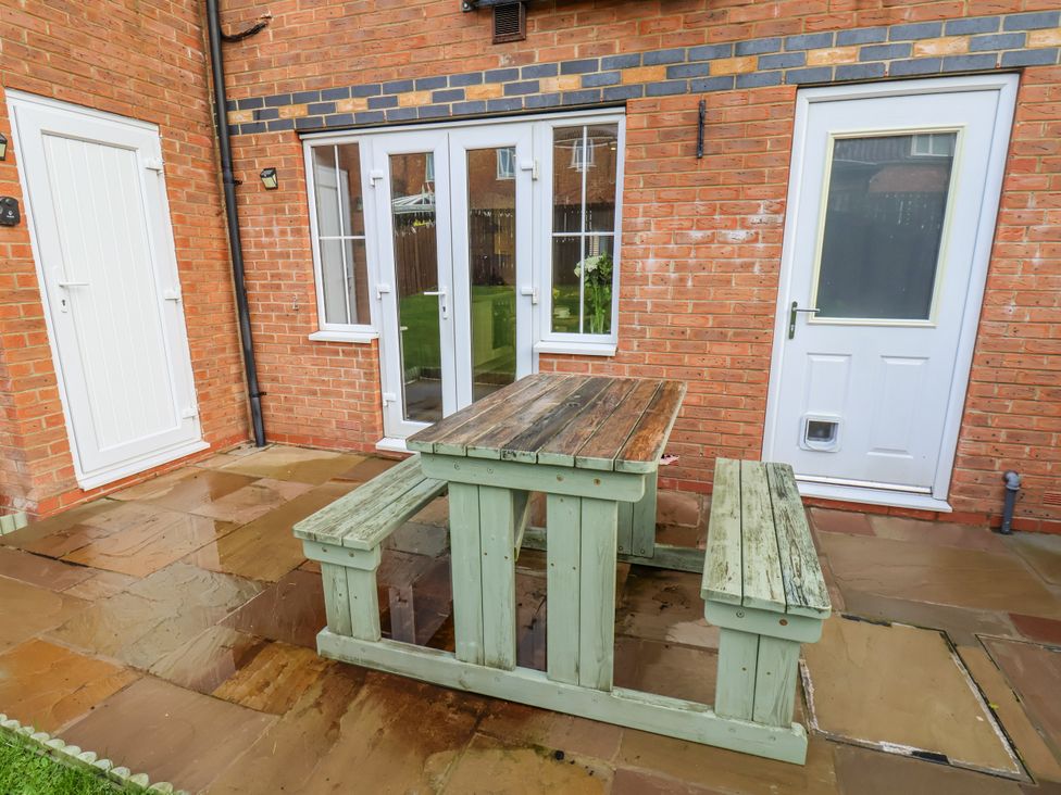 An outdoor area with a table and benches at Pearl Stone House in Whitby