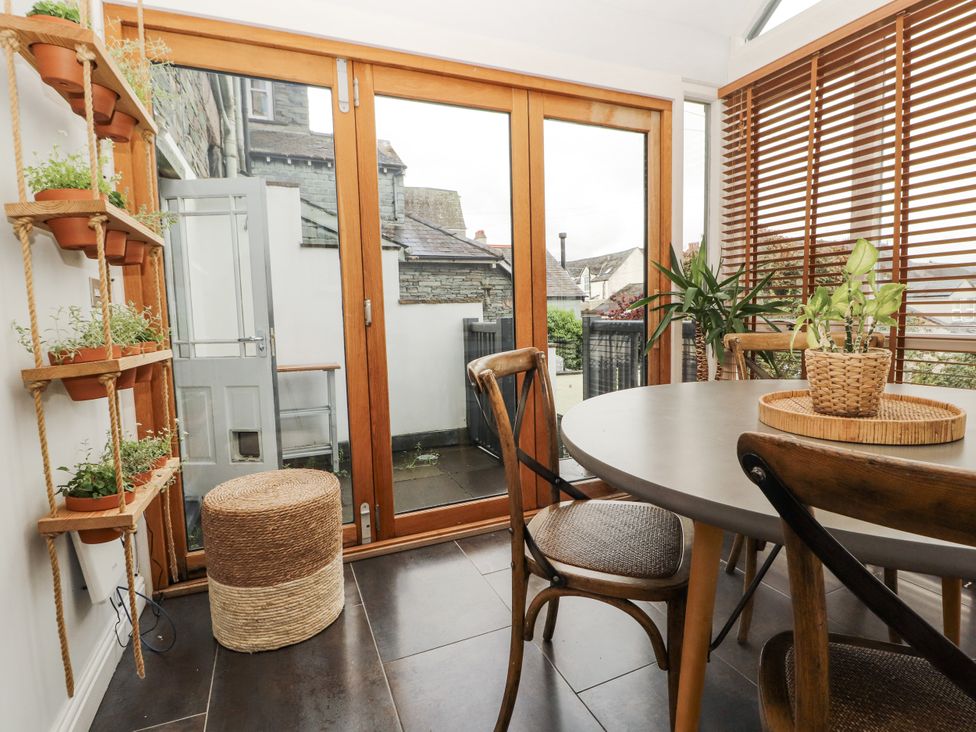 A conservatory with a round table and potted plants at 43 Station Road in Keswick