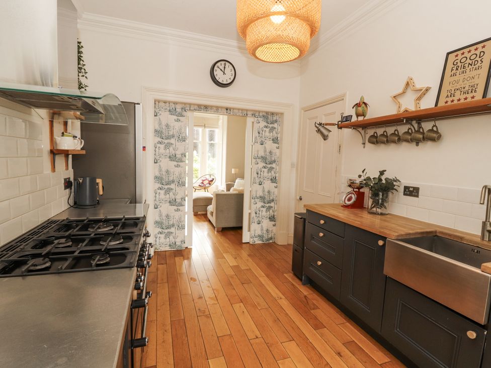 A kitchen with a gas stove and a large sink at 43 Station Road in Keswick