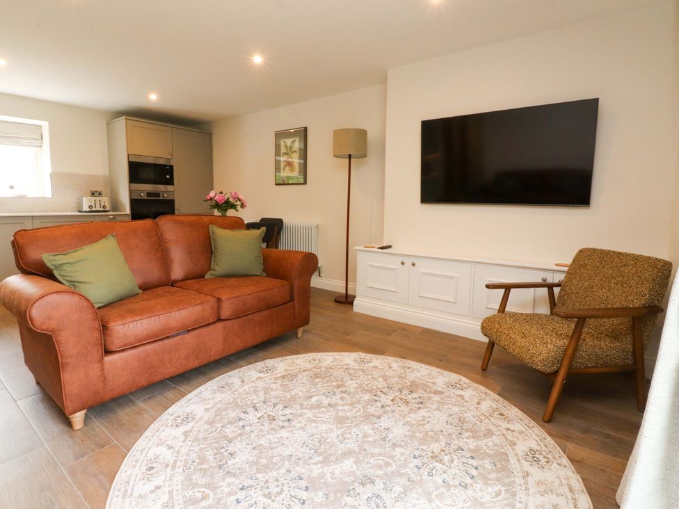 A living room with a sofa and television at Heron View 