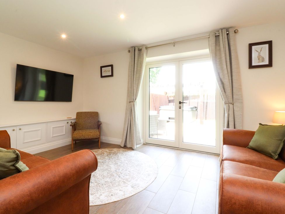 A living room with a television and patio doors at Heron View