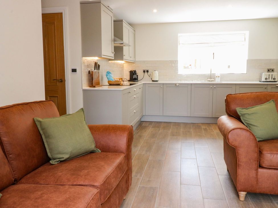 A kitchen with a sofa and appliances at Heron View 