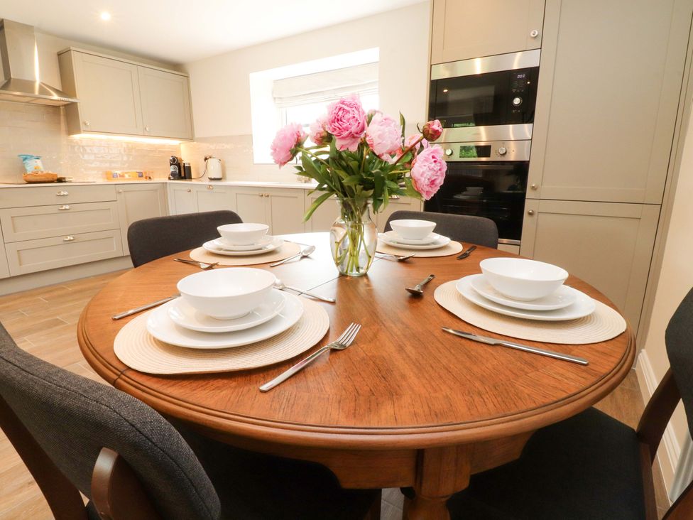 A kitchen with a dining table set for four at Heron View