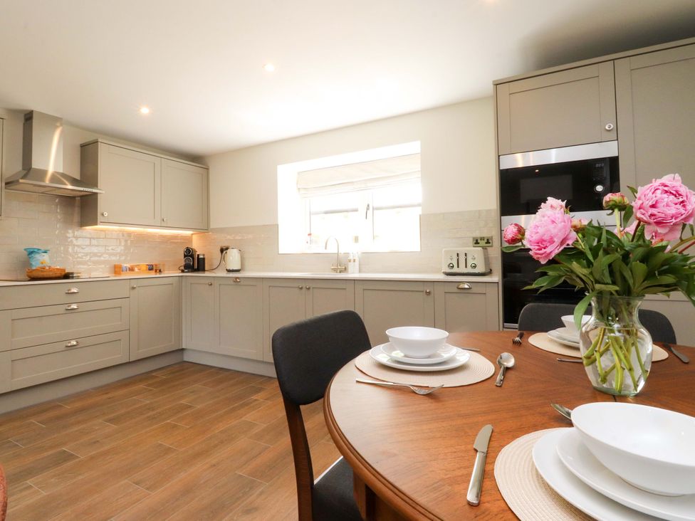 A kitchen with cooking appliances and a dining table at Heron View