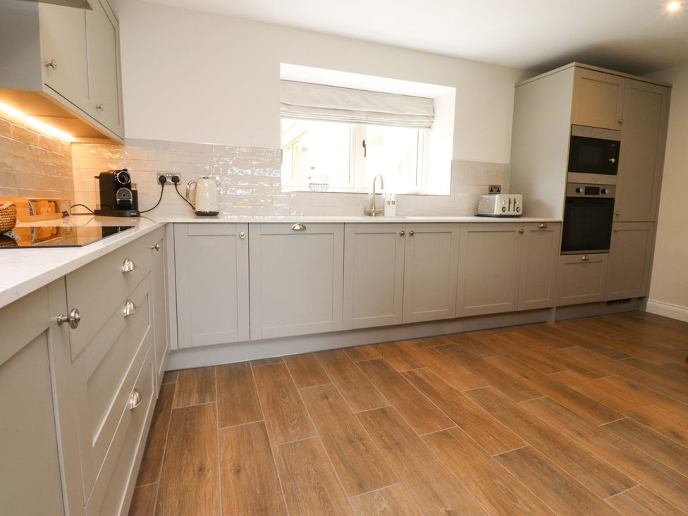 A kitchen with cabinets, sink, and appliances at Heron View