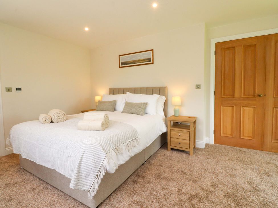 A bedroom with a bed and nightstand at Heron View