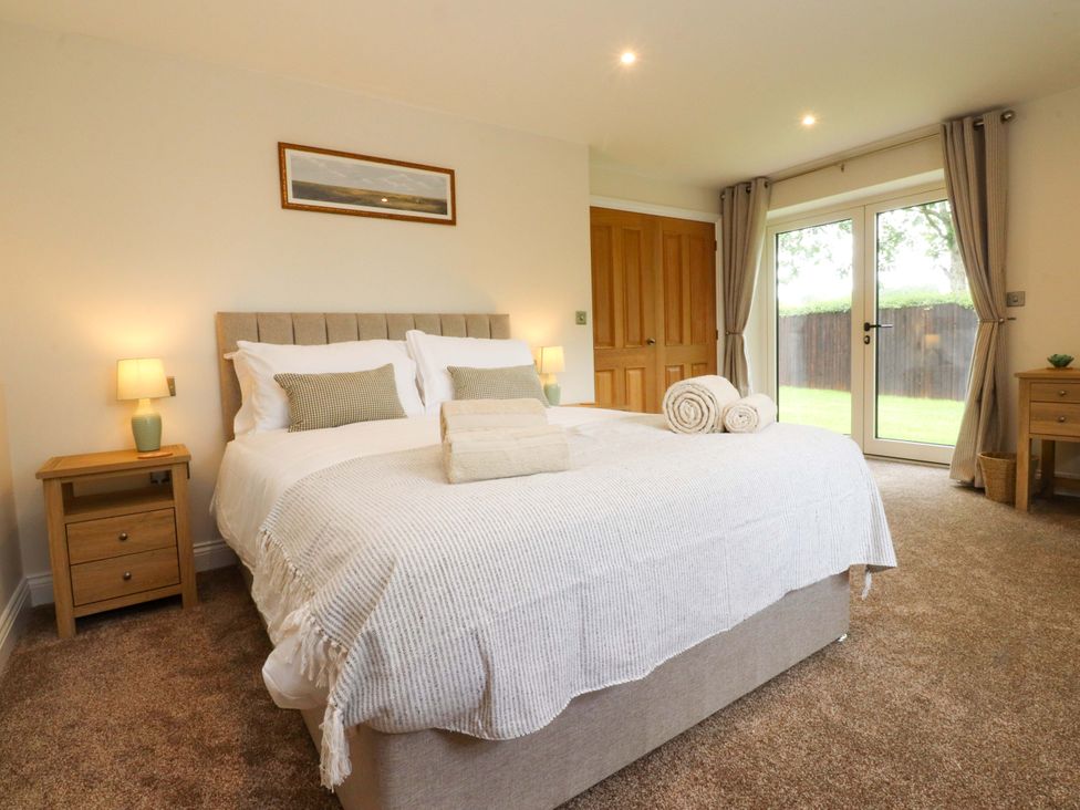 A bedroom with a bed and bedside tables at Heron View