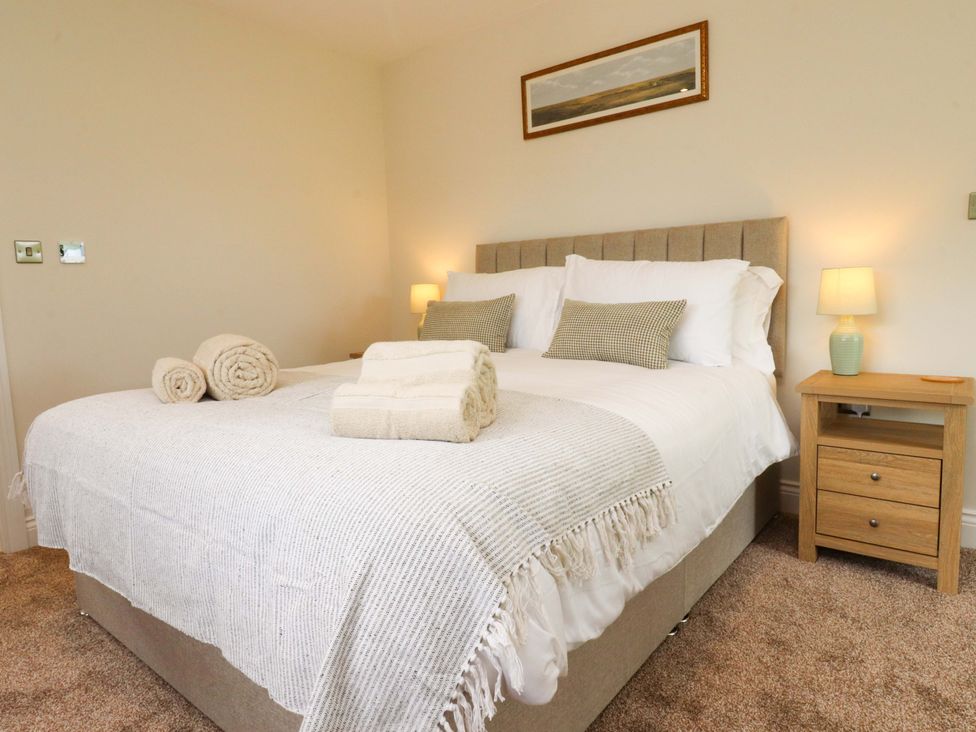 A bedroom with a bed and nightstand at Heron View