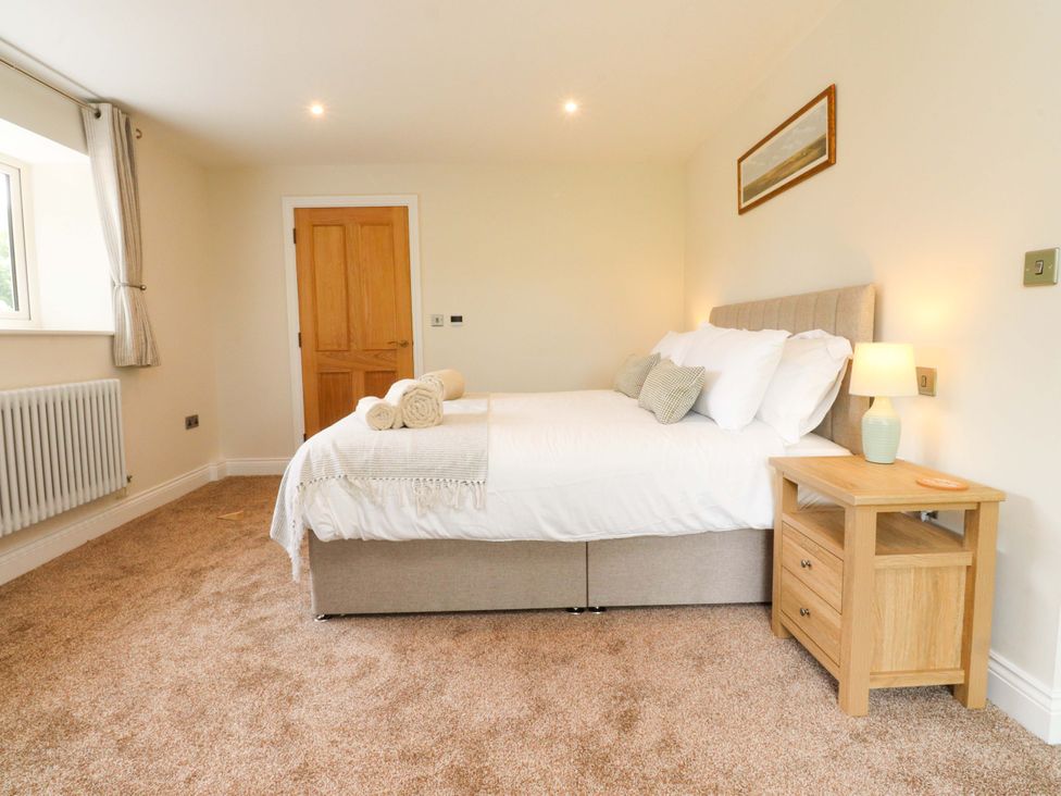 A bedroom with a bed and nightstand at Heron View