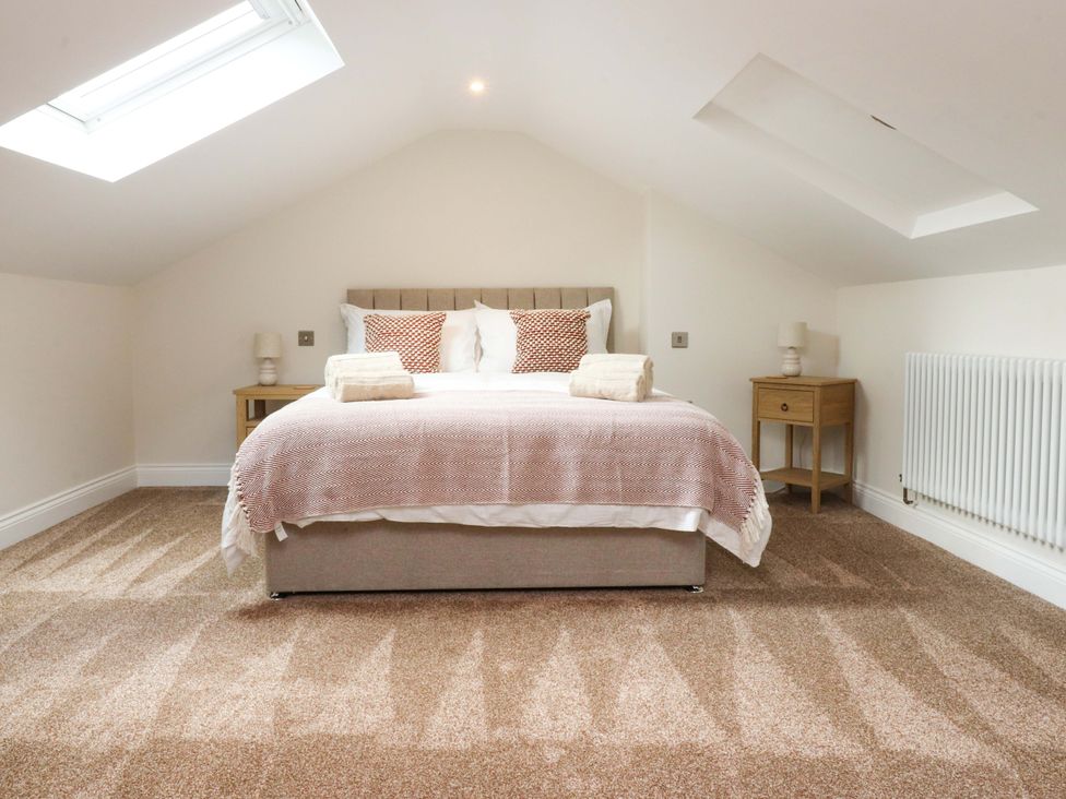 A bedroom with a bed and side tables at Heron View