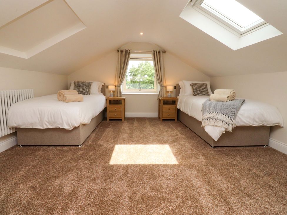 A bedroom with two single beds and a window at Heron View