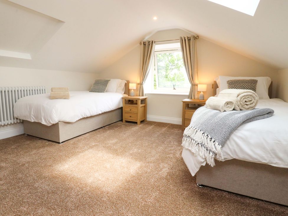 A bedroom with two beds and a window at Heron View