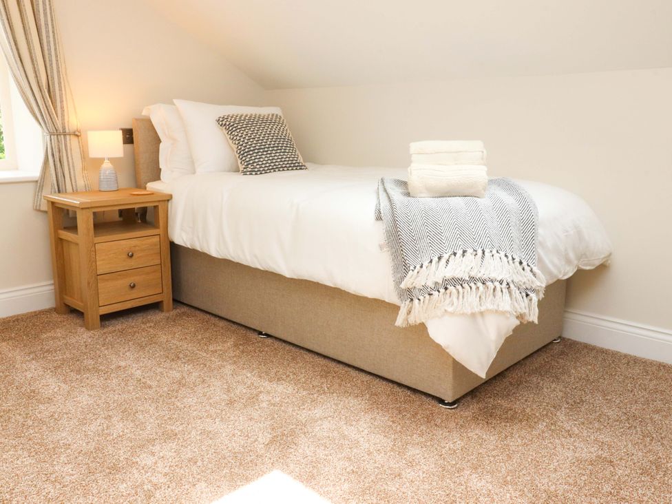 A bedroom with a bed and nightstand at Heron View