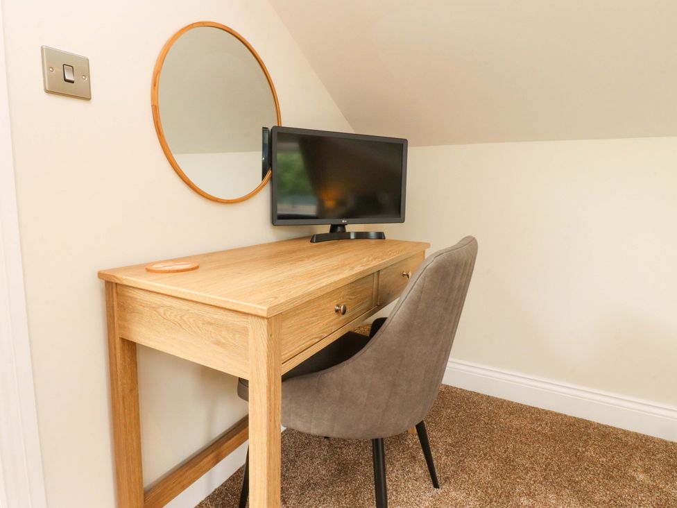 A workspace with a desk and television at Heron View
