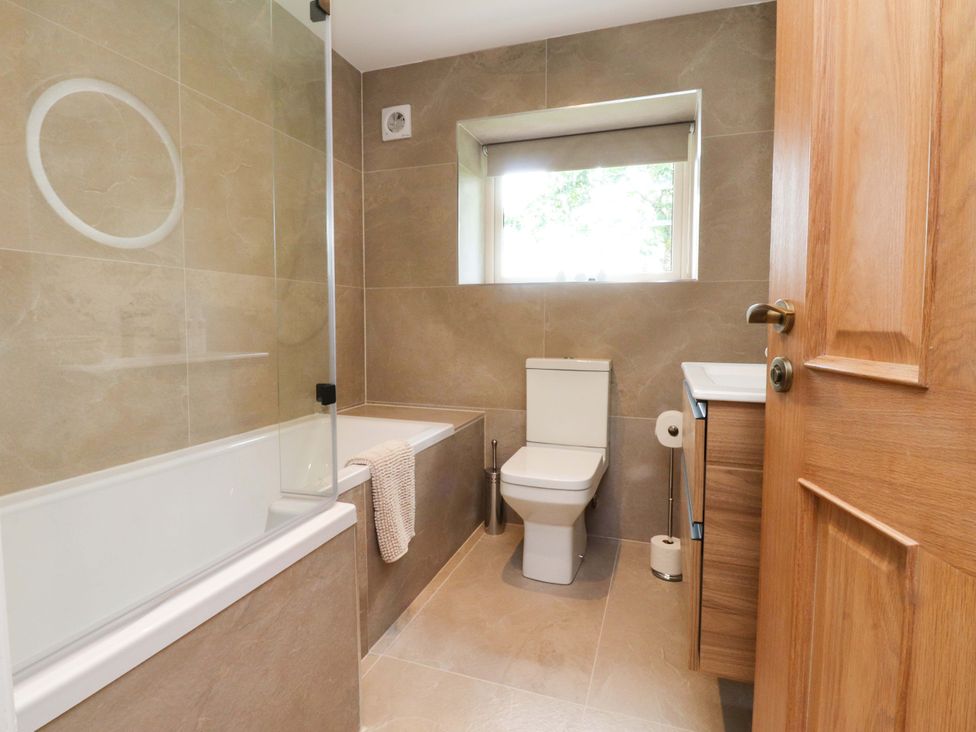 A bathroom with a bathtub, toilet, and sink at Heron View 