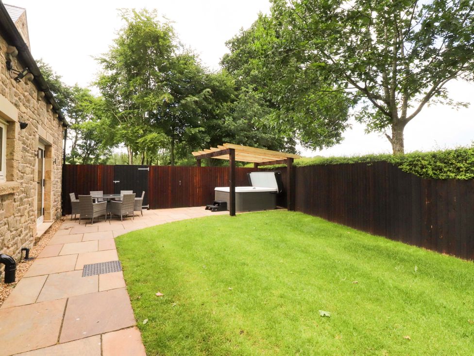 A garden with a hot tub and seating area at Heron View