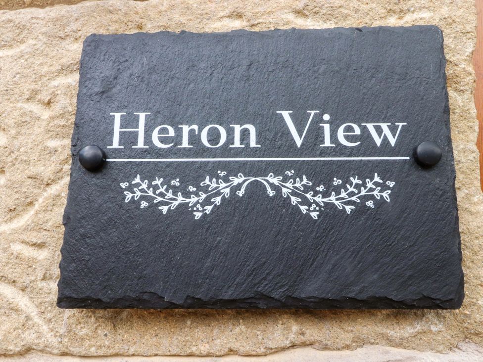 A slate plaque with the name Heron View mounted on a stone wall