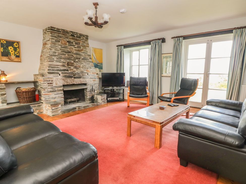 A living room with a fireplace and furniture at Tremorla in Boscastle