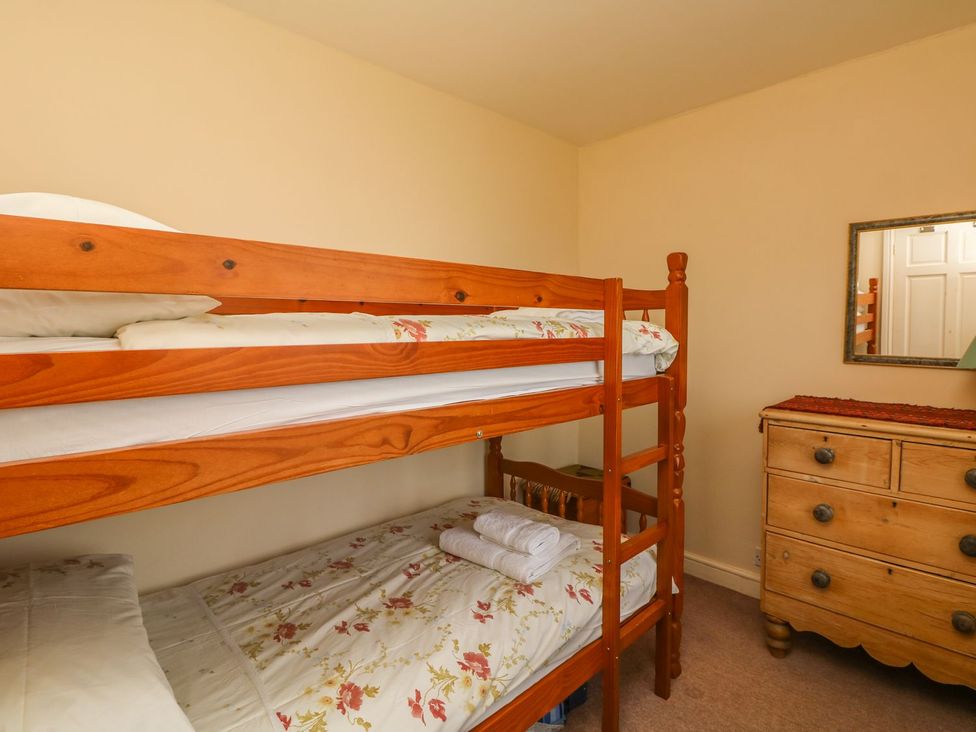 A bedroom with a bunk bed and dresser at Tremorla in Boscastle