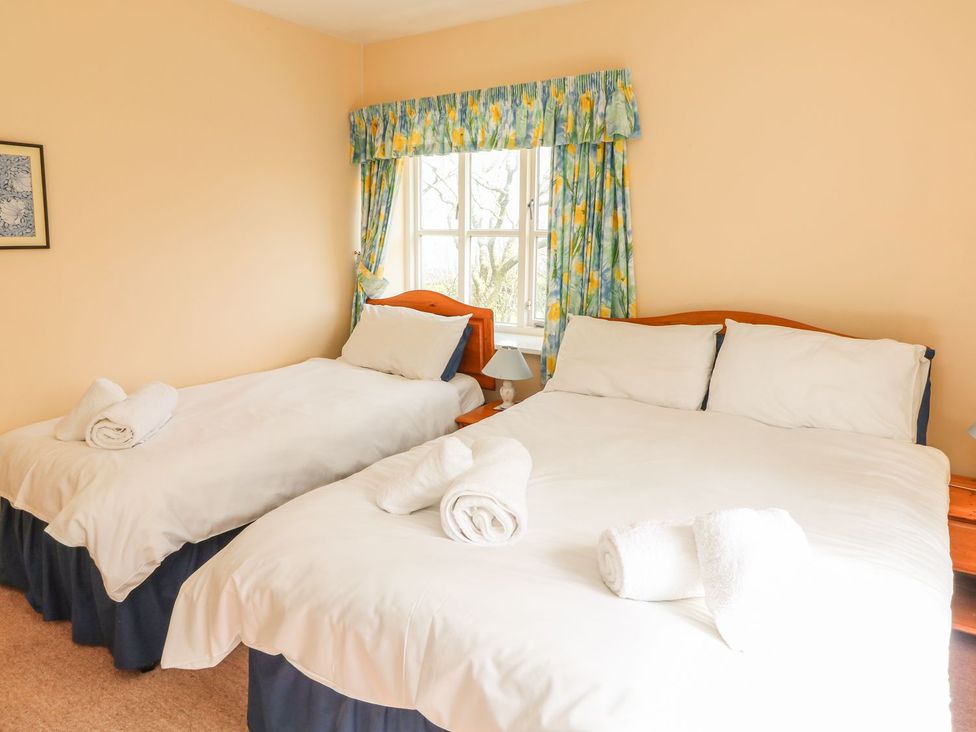 A bedroom with two beds and a window at Tremorla in Boscastle