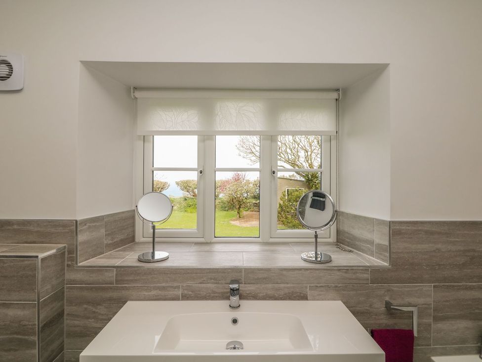 A bathroom with a sink and mirrors at Tremorla in Boscastle