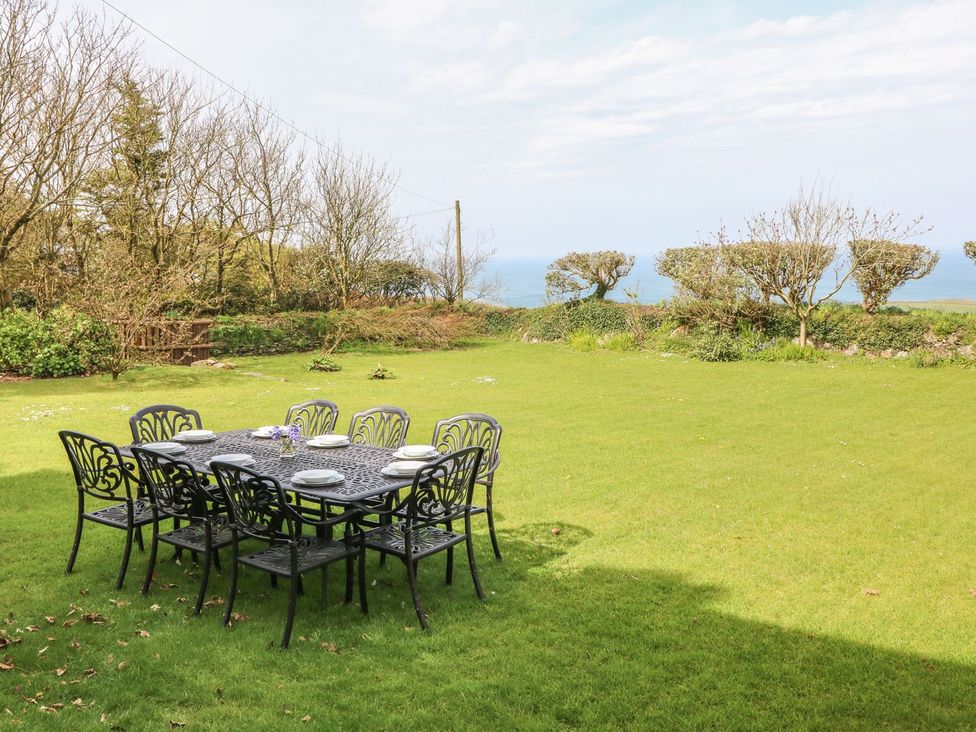 A garden with a table and chairs overlooking the sea at Tremorla in Boscastle
