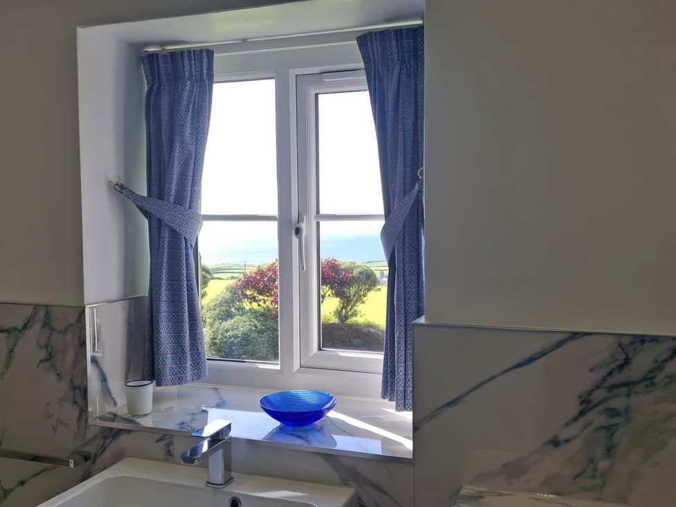 A bathroom with a window and a sink at Tremorla in Boscastle