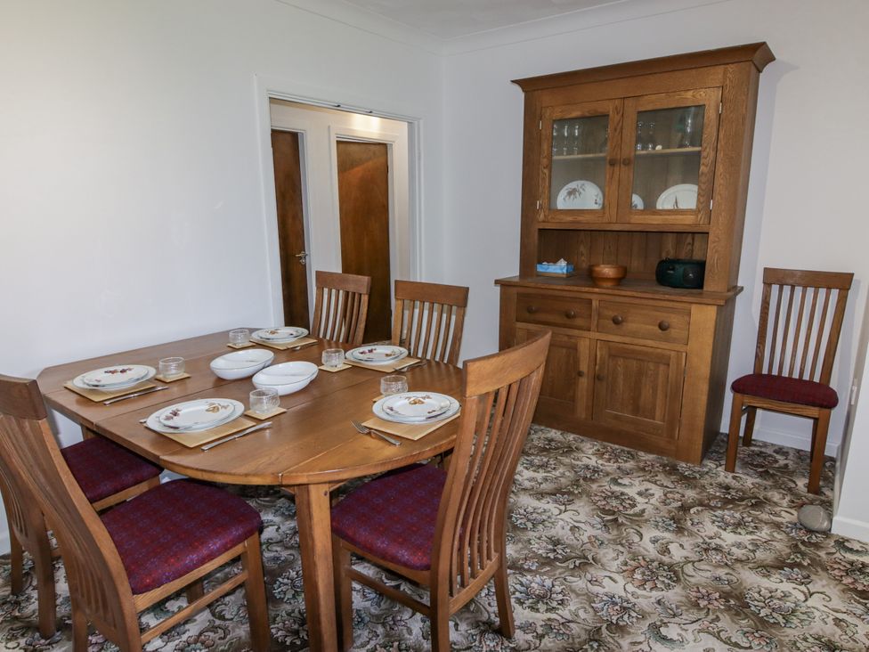 A dining room with a table set for meals at No.1 Vanderhoof Way Saundersfoot
