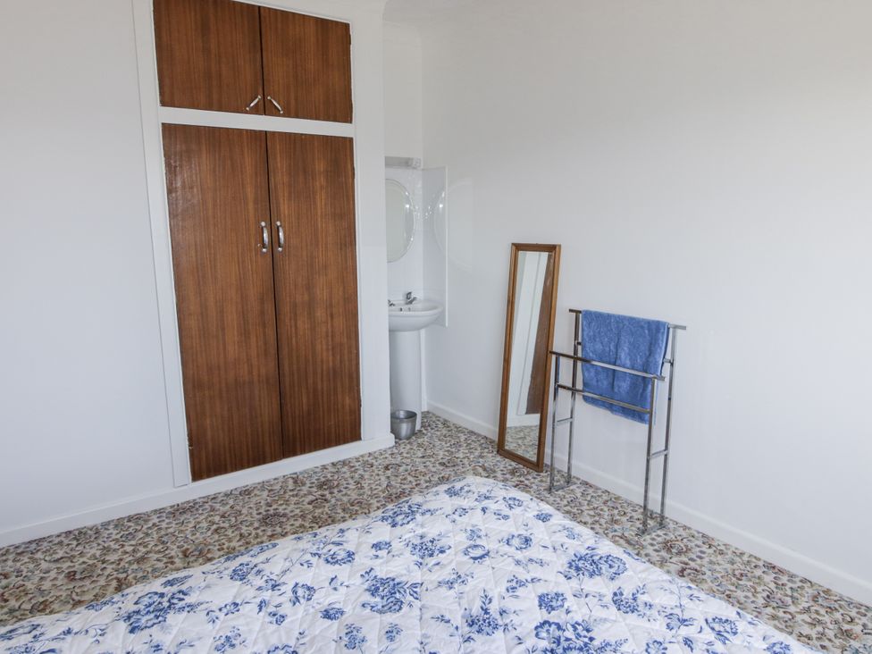 A bedroom with a bed and a wardrobe at No.1 Vanderhoof Way Saundersfoot