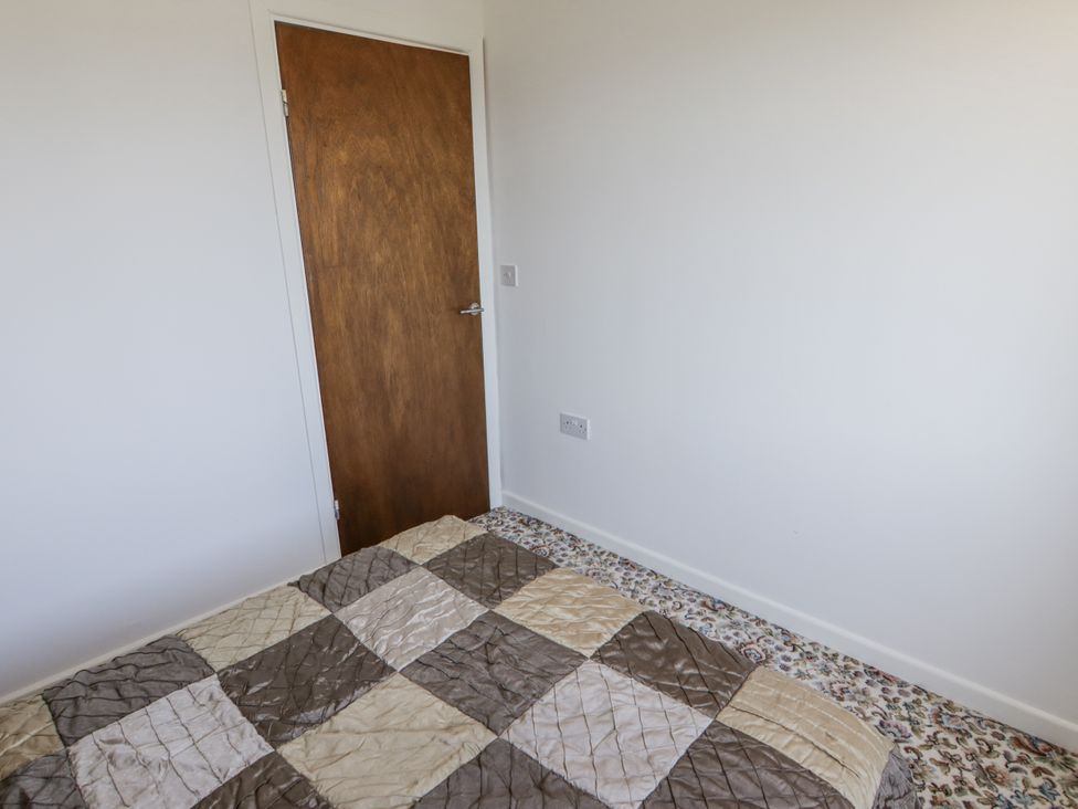 A bedroom with a bed and door at No.1 Vanderhoof Way Saundersfoot
