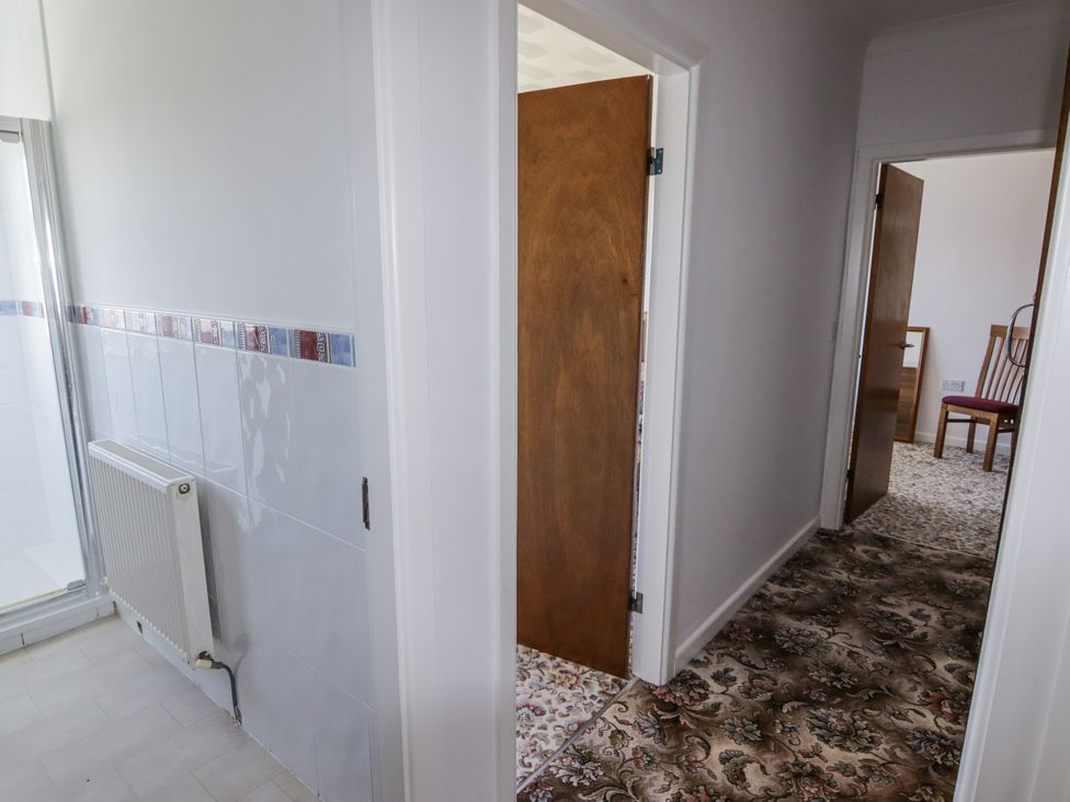 A hallway with a radiator and a shower door at No.1 Vanderhoof Way Saundersfoot