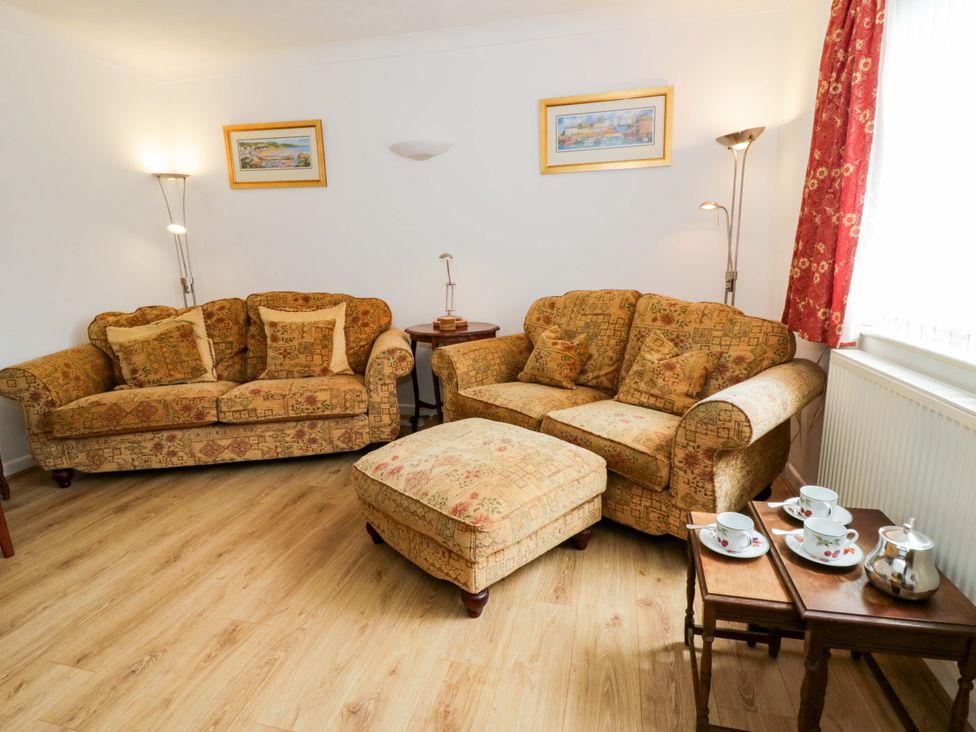 A living room with sofas and a tea set at No.1 Vanderhoof Way Saundersfoot