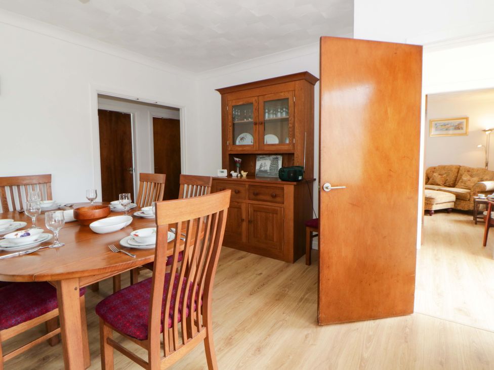 A dining room with a wooden table and chairs at No.1 Vanderhoof Way Saundersfoot
