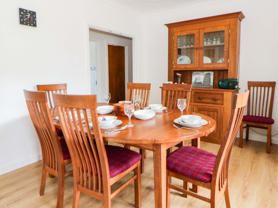 A dining room with a table set for meals at No.1 Vanderhoof Way Saundersfoot