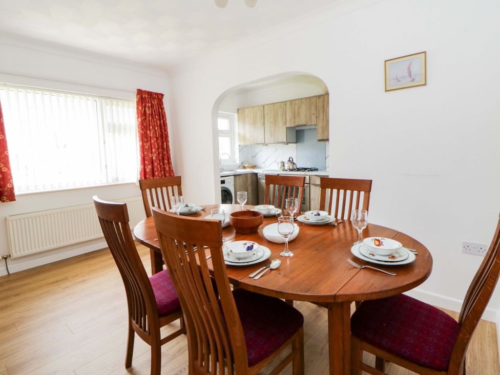 A dining room with a wooden table and chairs at No.1 Vanderhoof Way in Saundersfoot
