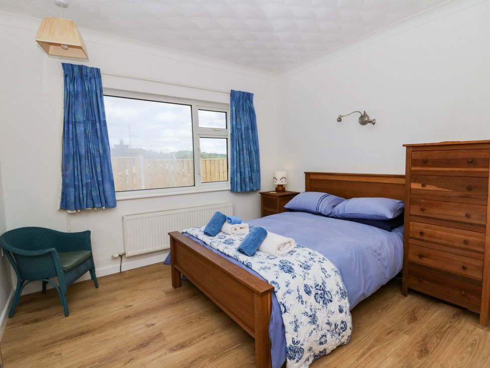 A bedroom with a bed and dresser at No.1 Vanderhoof Way in Saundersfoot