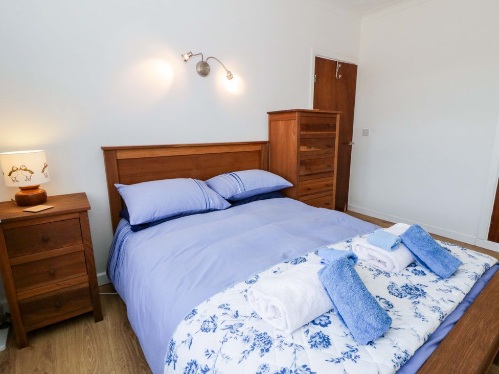 A bedroom with a bed and bedside lamp at No.1 Vanderhoof Way Saundersfoot