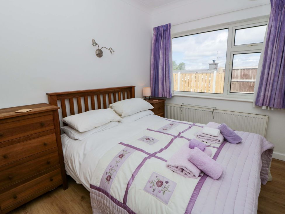A bedroom with a bed and curtains at No.1 Vanderhoof Way, Saundersfoot