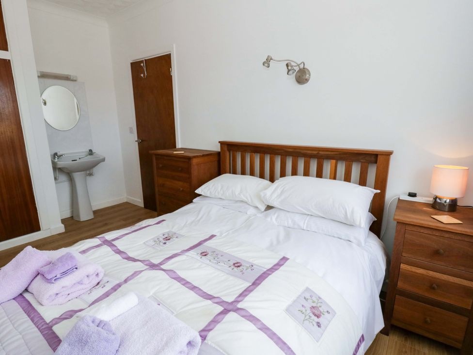 A bedroom with a bed and a mirror at No.1 Vanderhoof Way in Saundersfoot