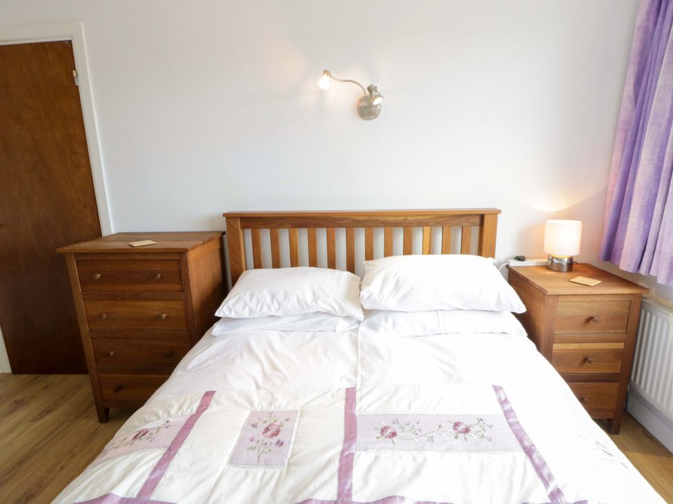 A bedroom with a double bed and wooden furniture at No.1 Vanderhoof Way in Saundersfoot