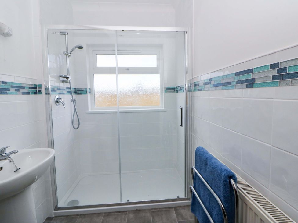A bathroom with a shower and sink at No.1 Vanderhoof Way Saundersfoot