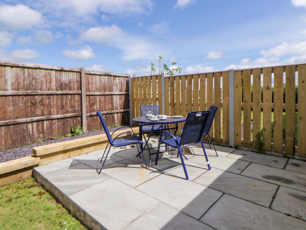 A garden with a table and chairs at No.1 Vanderhoof Way Saundersfoot