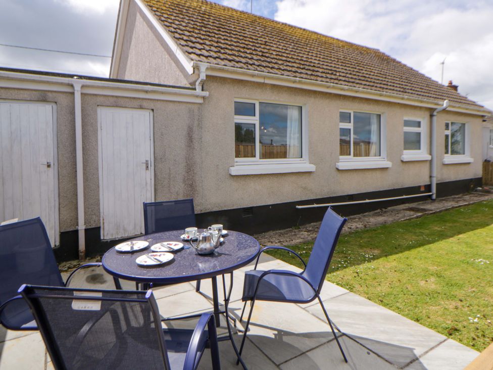 A garden with a table and chairs at No.1 Vanderhoof Way Saundersfoot