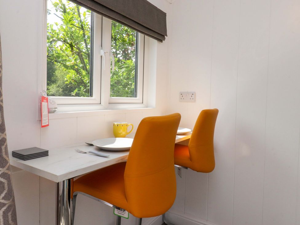 A dining area with two chairs and a table at Shepherds Hut 1