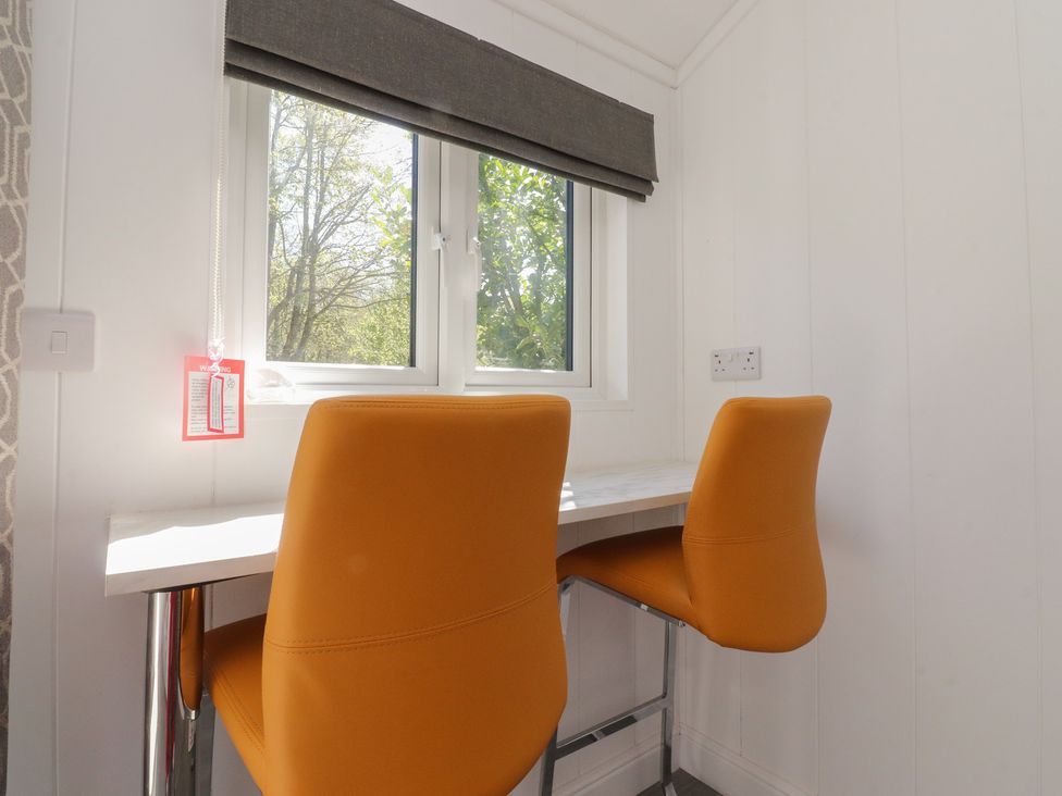 An office area with two orange chairs and a table near a window at Butterfly Hut 1 Forton near Garstang