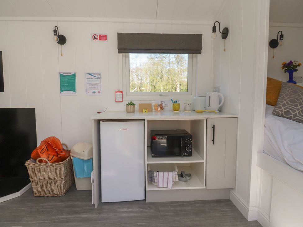 A kitchen area with refrigerator, microwave, and kettle at Butterfly Hut 1 Forton near Garstang