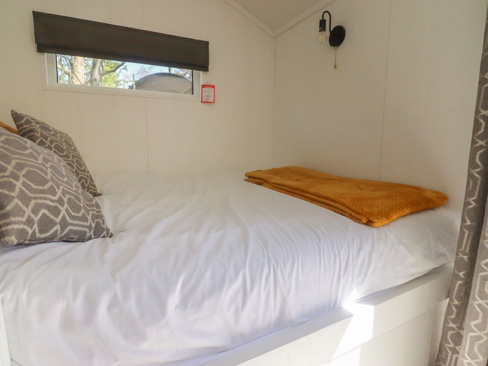 A bedroom with a bed and pillows at Butterfly Hut 1 Forton near Garstang