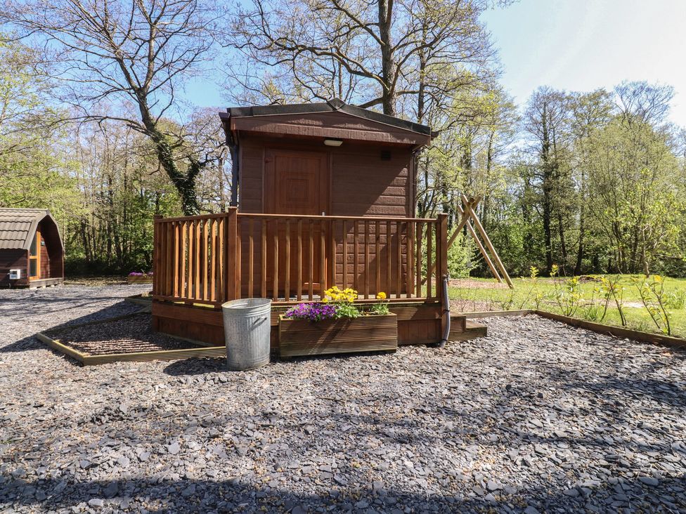 A wooden cabin with a deck and flower box at Butterfly Hut 1 Forton near Garstang